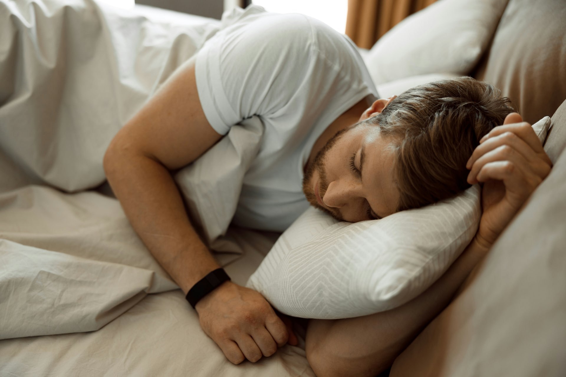 A man resting on his side with a wristband, illustrating heart rate during sleep
